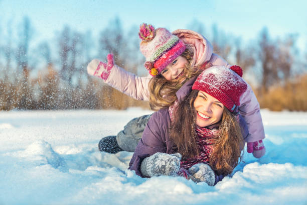 istock Active mother and daughter playing in winter park 1190126225