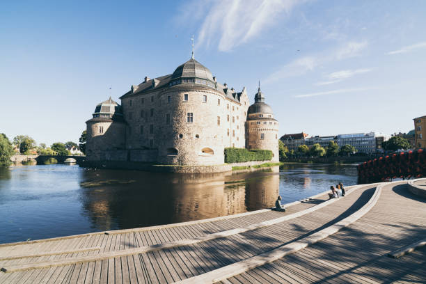 People relaxing in front of ancient Orebro castle, Sweden stock photo