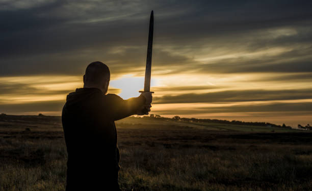 A lone redhead individual Scottish viking sword wielding warrior man at dawn