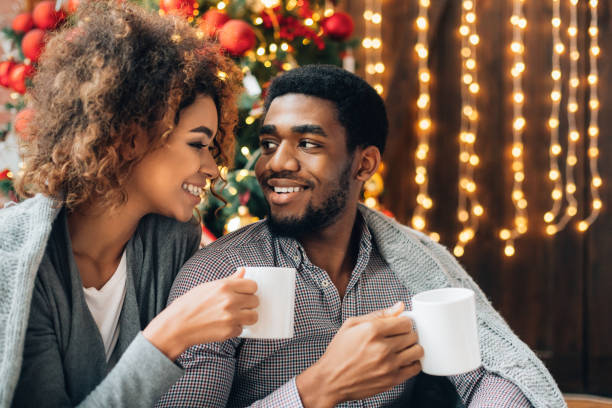 istock Young couple drinking coffee at Christmas tree 1190128359