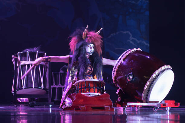 istock Taiko drummer in a wig and a demon mask performs on stage with drum on a dark background. Demon from Japanese mythology. 1190128518