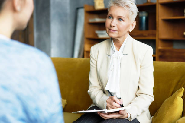 istock Experienced middle aged female human resources manager conducting job interview with unrecognizable woman candidate listening to her attentively and making notes. Occupation and career concept 1190128611