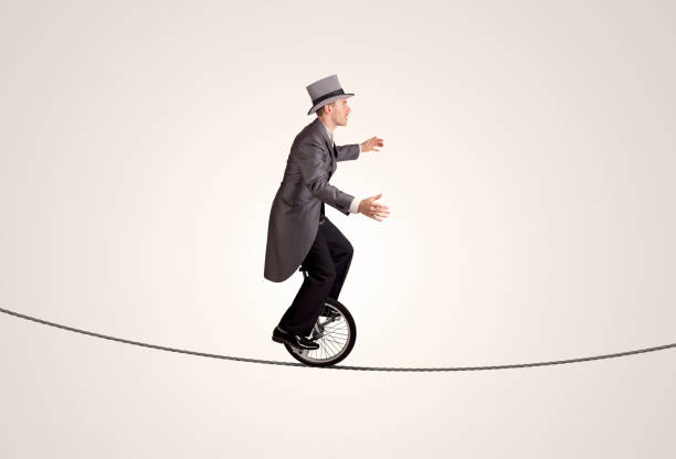 istock Extreme business man riding unicycle on a rope 1190129861