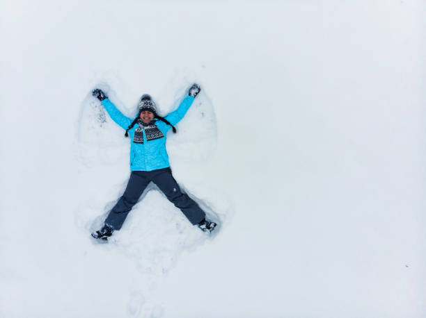 Horizontal view of a drawing of a Christmas snow angel etched into a snowdrift on a sunny winter day.