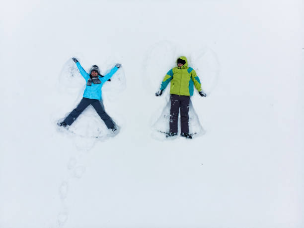 istock couple having fun making snow angel 1190129949