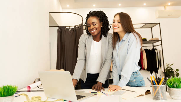 istock Two Diverse Tailors Using Laptop Working On Clothing Collection Indoor 1190130039