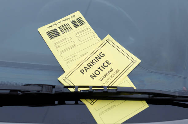 istock Yellow warning parking notice and parking infaction notice on the grey windshield 1190130995