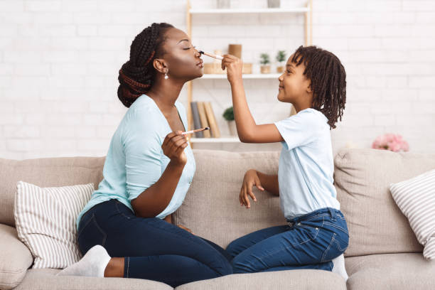 istock Little afro girl doing makeup for her mom 1190131467