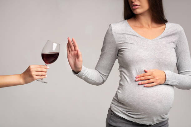 donna incinta gesticolare stop a bicchiere di vino, studio, ritagliato - abdomen addiction adult alcohol foto e immagini stock