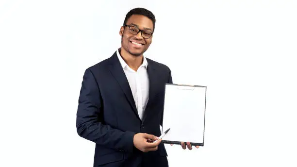 Photo of Black guy in suit showing blank clipboard