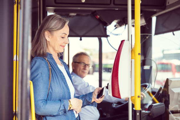 passager féminin payant le tarif à l'entrée du bus - farnes photos et images de collection