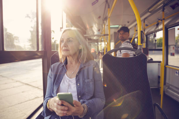 donna che ascolta musica mentre viaggia in autobus - transportation bus mode of transport public transportation foto e immagini stock