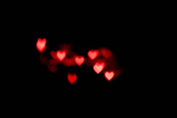 istock Pink hearts bokeh on black background. Festive Texture for holidays 1190135495