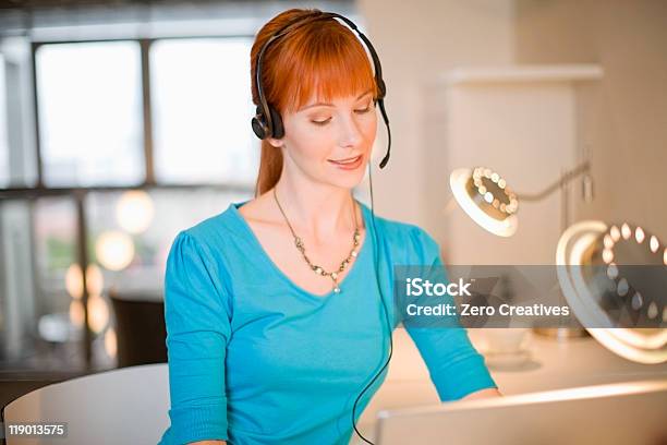 Businesswoman In Headset Using Laptop Stock Photo - Download Image Now - Call Center, Illuminated, 25-29 Years
