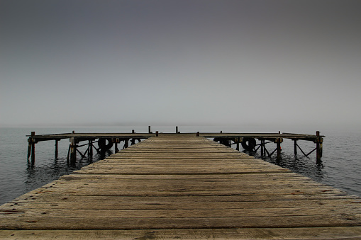 Old wooden pier disappearing in the mist