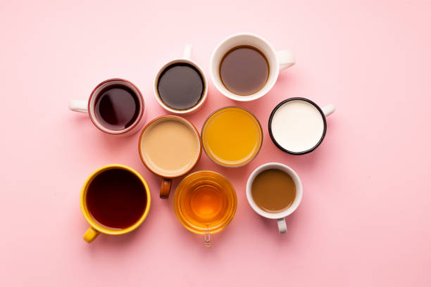 istock Mugs glasses with various traditional drinks coffee tea juice on pink background. Flat layout top view. Drinks concept. 1190137403