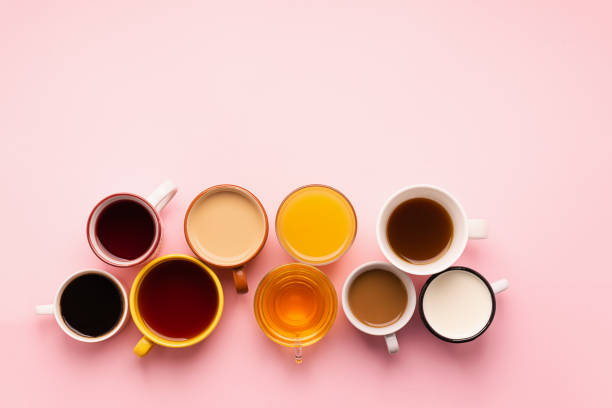 istock Mugs glasses with various traditional drinks coffee tea juice on pink background. Flat layout top view. Drinks concept. 1190137404