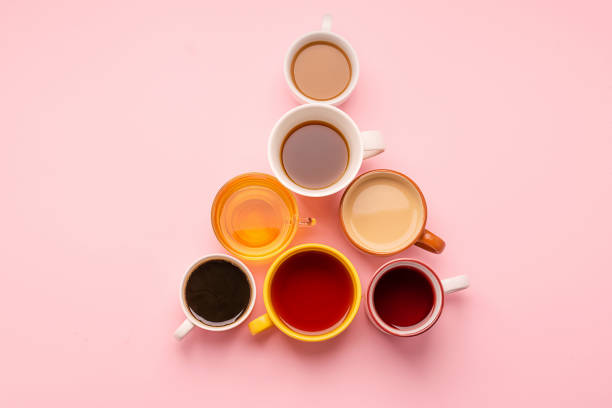 istock Mugs and glasses with various traditional drinks stand with a pyramid on a pink background. Drinks concept. 1190137424