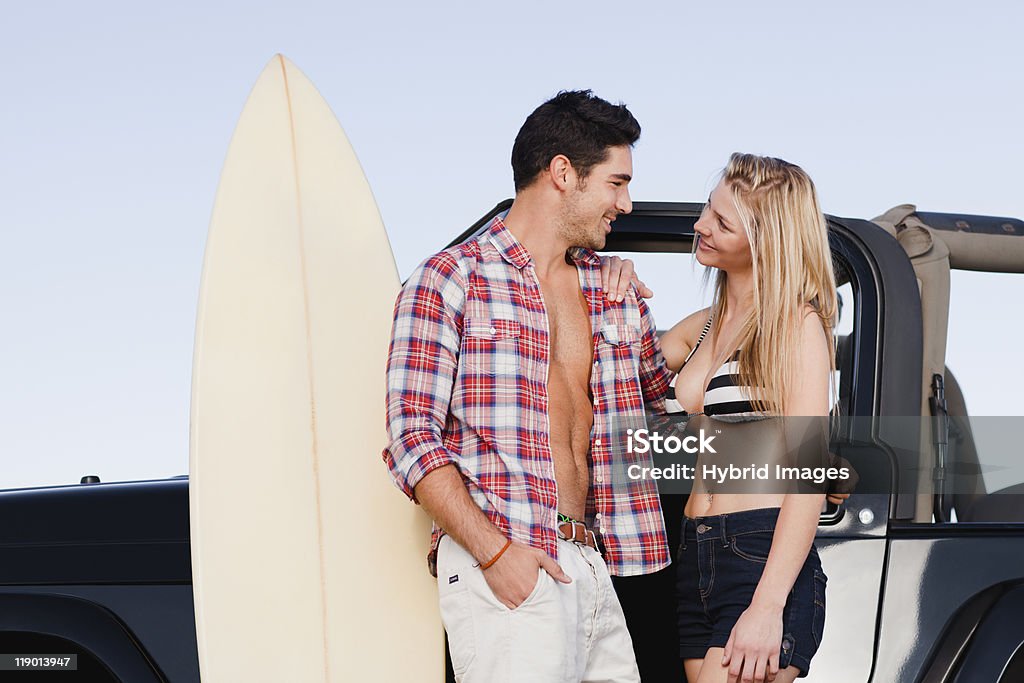 Smiling couple hugging by jeep  Embracing Stock Photo