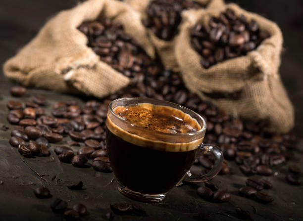 istock Coffee cup and sacks with coffee beans on a black table. 1190144117