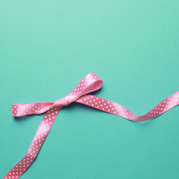 istock Decorative pink bow ribbon on mint background 1190144124