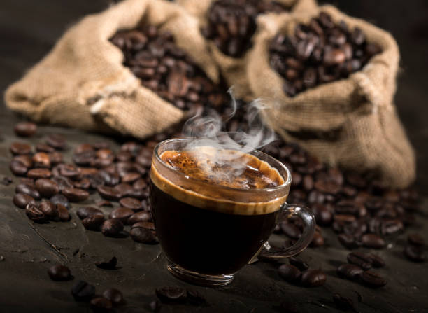 istock Coffee cup and sacks with coffee beans on a black table. 1190144137