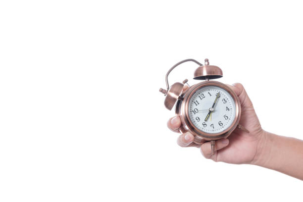 istock Hand holding vintage alarm clock setting at 7am and showing time over eight o'clock for being late 1190144534