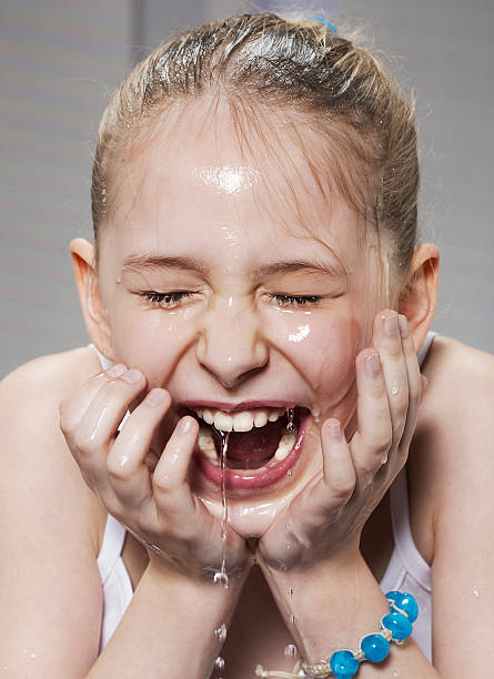 ridere ragazza di lavarsi il viso - splashing color image front view head and shoulders foto e immagini stock