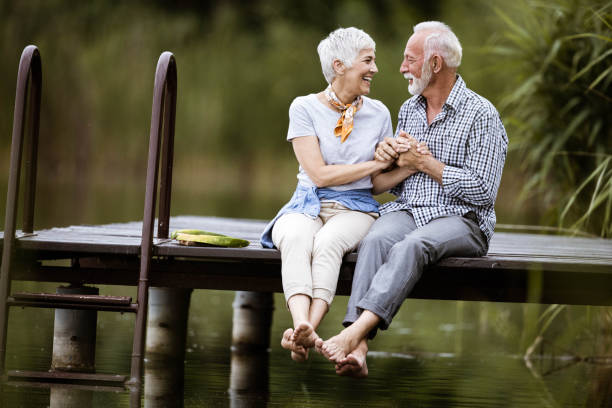 istock Loving senior couple talking while relaxing on a pier. 1190145866