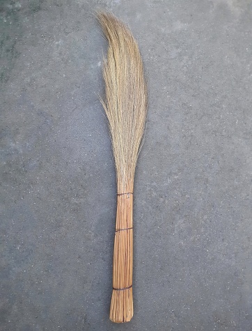 Grass flower broom for house cleaning on the floor.