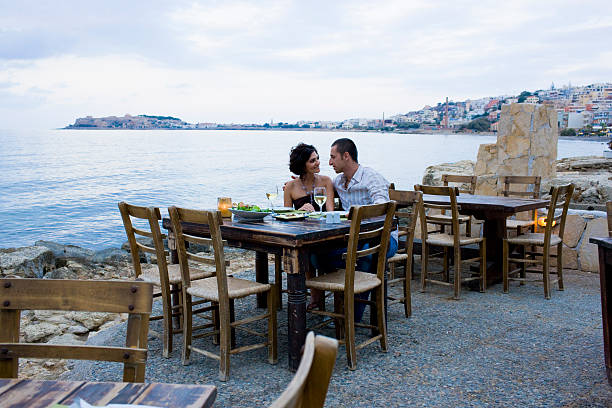 Couple eating at waterfront cafe  greece travel stock pictures, royalty-free photos & images