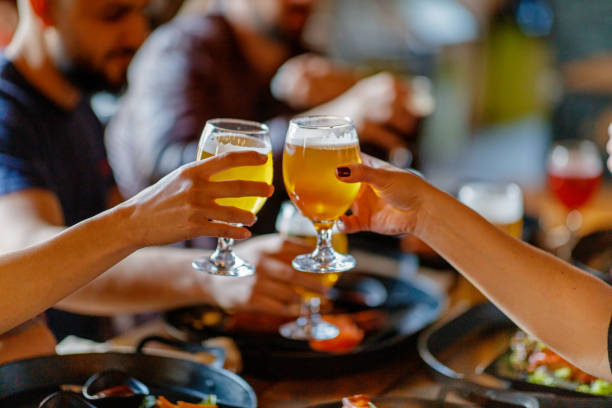 women toasting with beer in pub - gastro pub imagens e fotografias de stock