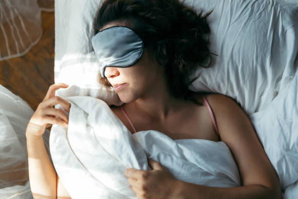 istock woman sleeping in mask in bed bright light on face 1190147599