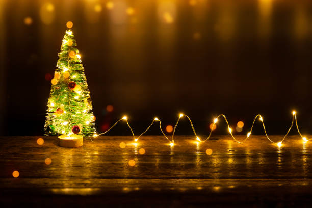 istock Christmas tree and light garland on old wooden table 1190149451