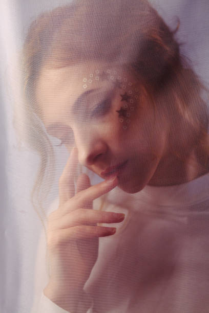 istock Young beautiful redhead girl behind a light transparent fabric 1190151836