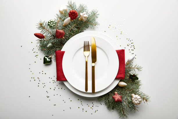istock top view of festive Christmas table setting on white background with decorated pine branch and confetti 1190152423