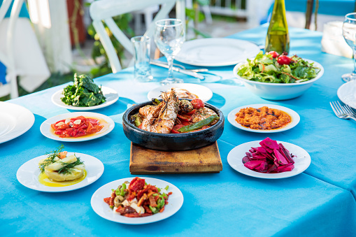 Shrimp, Seafoods, appetizers and salads on the table in Fish Restaurant. Beach Restaurant in Greece or Turkey.