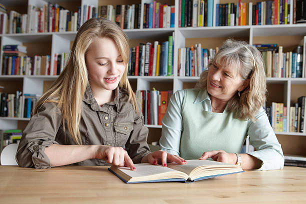 kobieta i wnuczka czytanie razem - adult student women mature adult library zdjęcia i obrazy z banku zdjęć