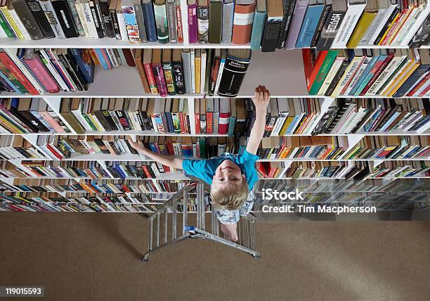 Boy Using Stepladder On Bookshelves Stock Photo - Download Image Now - High Angle View, Book, Large Group Of Objects