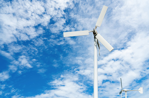 Wind turbine at wind farm on blue sky. Alternative and renewable energy concept. Sustainable electricity. Green energy concept. Small turbine. Clean energy industry. Eco friendly energy. Nature power.