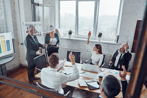 Top view of successful business professionals voting with show of hands while working together in the modern office