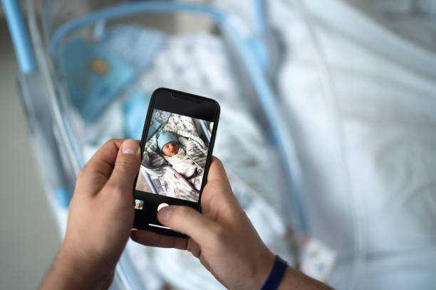 vater fotografiert sein neugeborenes im krankenhaus - am telefon fotos stock-fotos und bilder