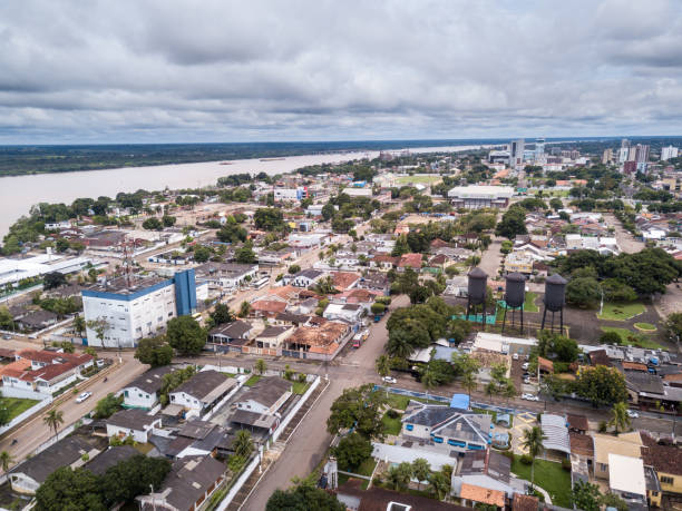 Aerial drone view of Porto Velho city center streets with "Praça das tres caixas dagua" square and Madeira river and Amazon rainforest in the background on cloudy winter day. Rondonia state, Brazil. Concept of environment, global warming, climate change, climate emergency,deforestation, logging and illegal timber. brics photos stock pictures, royalty-free photos & images