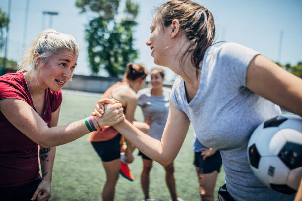Women soccer players shaking hands after match Group of women, female soccer players together outdoors on soccer field, two women shaking hands. football player girlfriend stock pictures, royalty-free photos & images