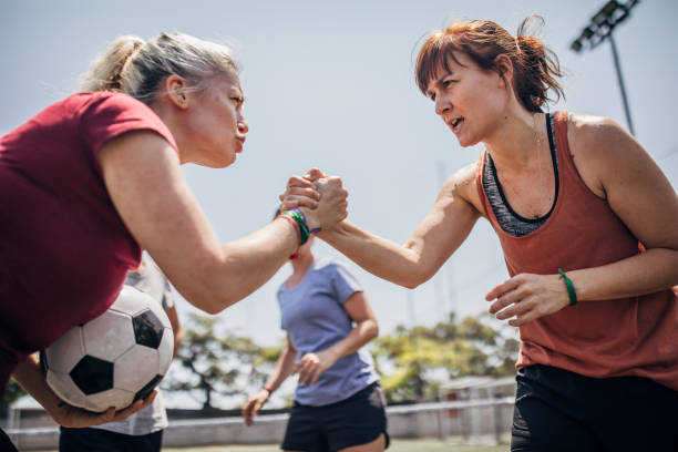 Female soccer players shaking hands before match Group of women, female soccer players together outdoors on soccer field, two women shaking hands. football player girlfriend stock pictures, royalty-free photos & images