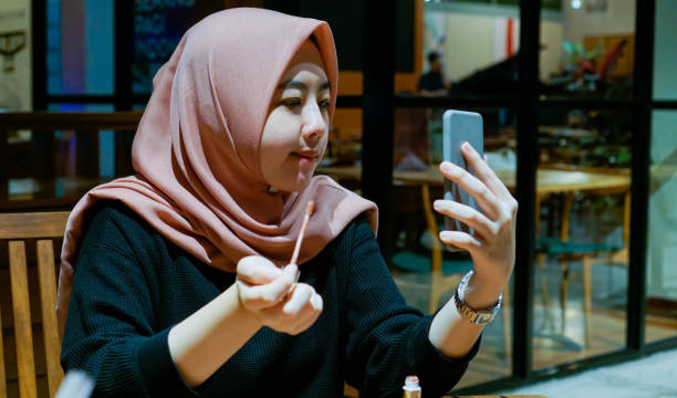 istock Millennial Asian Women Doing A MakeUp Using Smartphone 1190163152