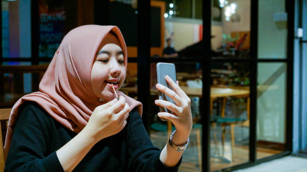 istock Millennial Asian Women Doing A MakeUp Using Smartphone 1190163170