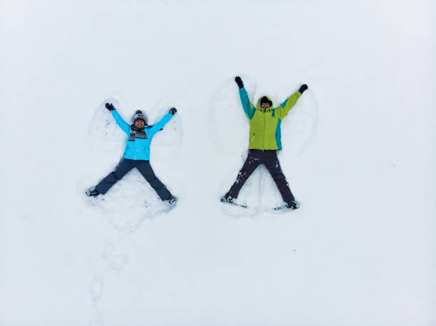 istock couple having fun making snow angel 1190167066