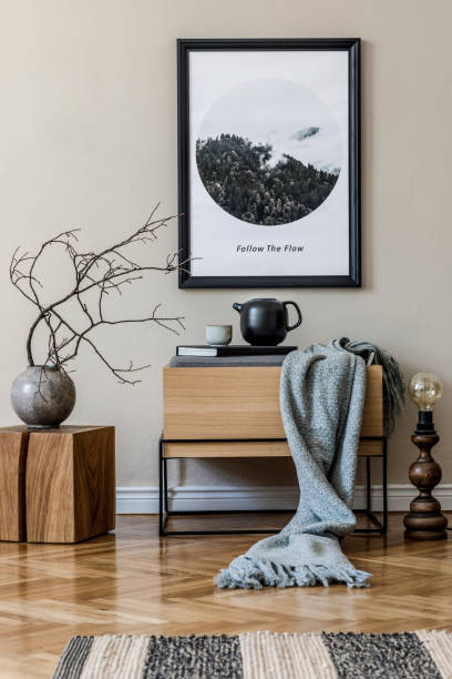 istock Modern scandinavian living room interior with black mock up poster frame, design commode, flowers in vase, retro lamp books and elegant accessories. Template. Stylish home decor. 1190167559