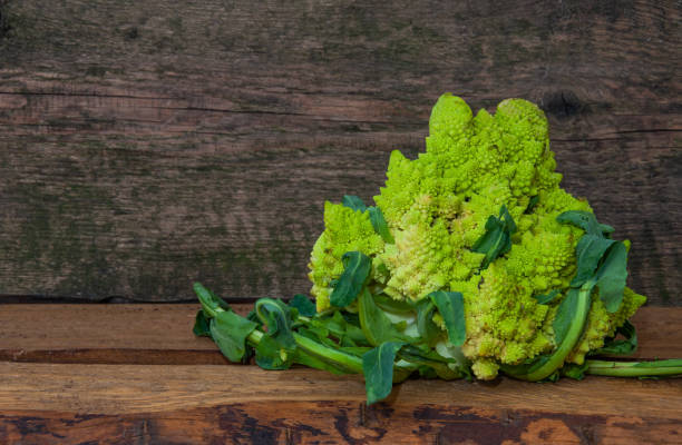 Fresh cabbage grade Romanesco on a wooden background, close-up Fresh cabbage grade Romanesco on a wooden background, close-up,Place for text. Copy space fractal plant cabbage textured stock pictures, royalty-free photos & images